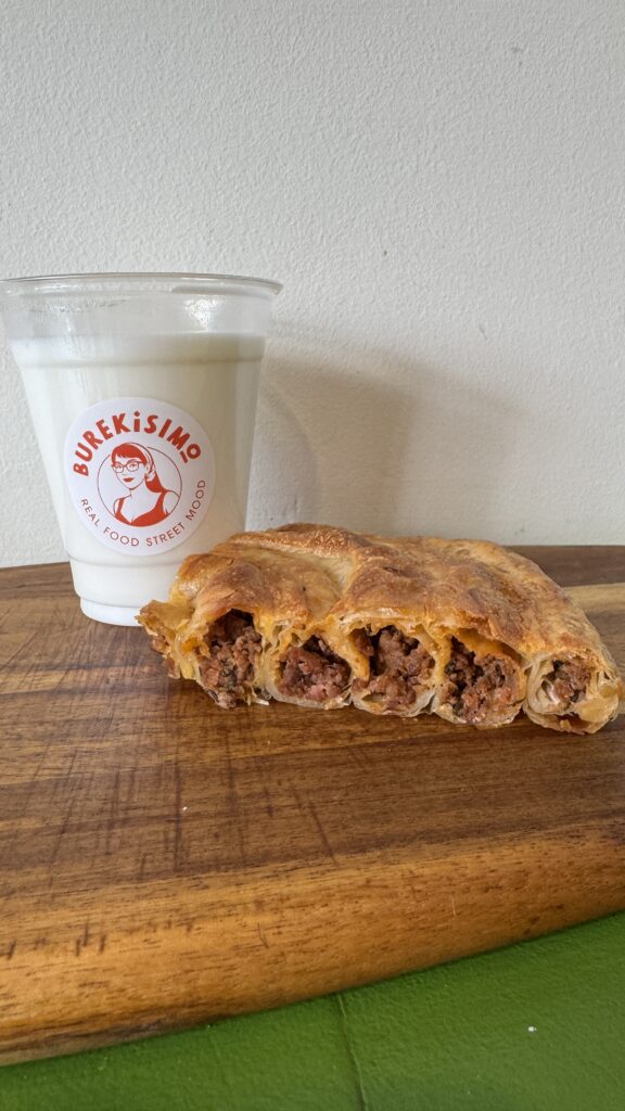 Burek/börek de carne en espiral cortado, con un vaso de ayran casero de Burekisimo