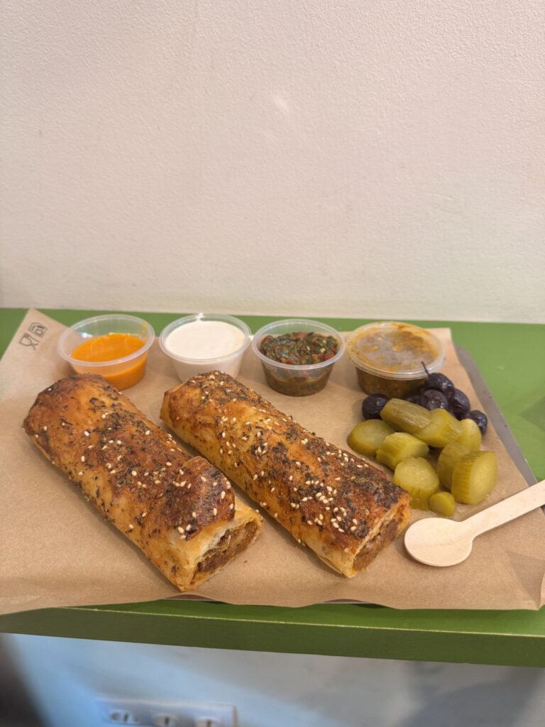Dos burek/börek con encurtidos, aceitunas y salsas caseras
