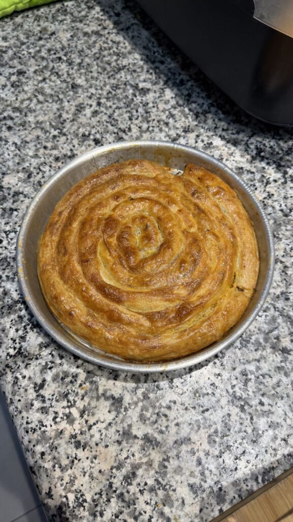 Burek/börek en espiral recién horneado en su bandeja redonda