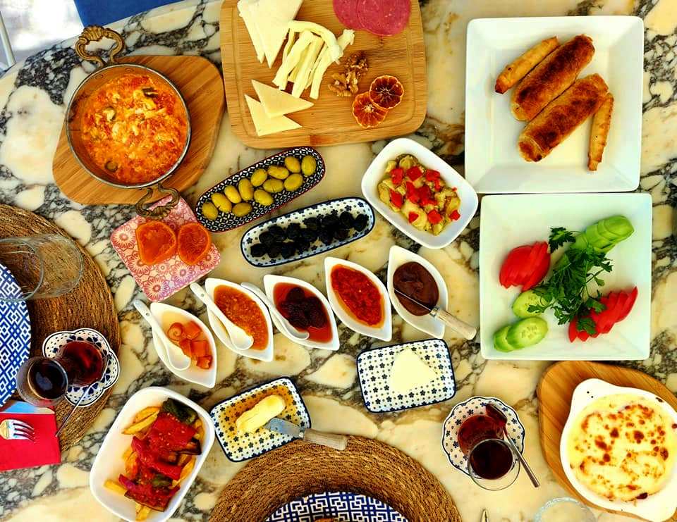 Desayuno turco (kahvaltı) con börek, quesos, aceitunas y té